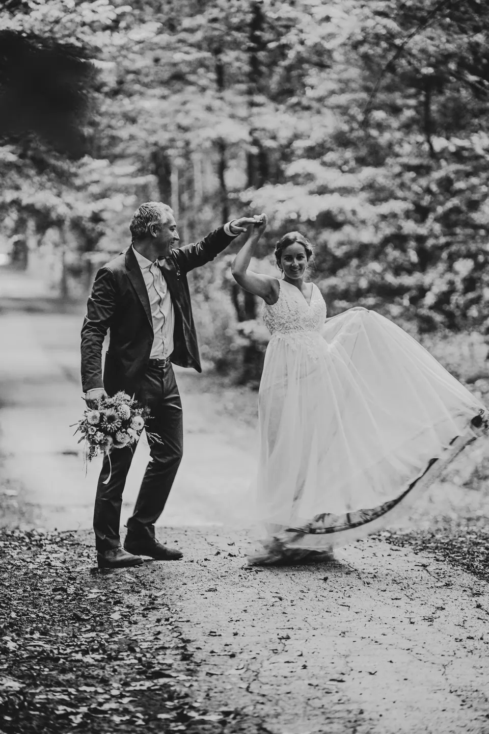Bruidspaar danst in het bos, zwart wit
