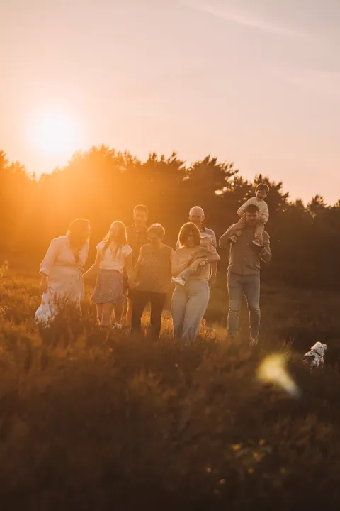 Grote familie in de heide tijdens zonsondergang
