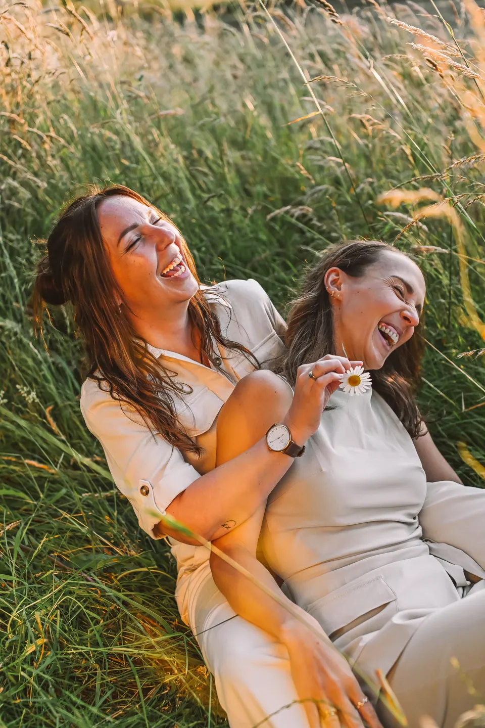Zus ligt lachend in het hoge gras