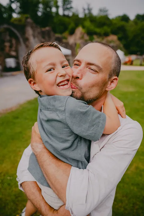 Papa geeft zijn lachende zoon een dikke kus