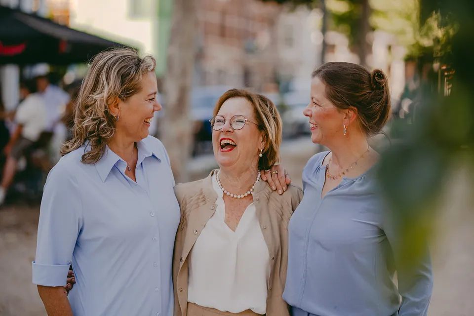 Drie vrouwen lachen samen in de stad