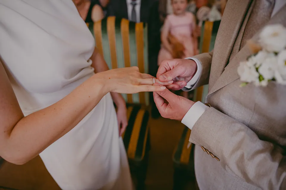 De ring glijdt aan de vinger van de bruid